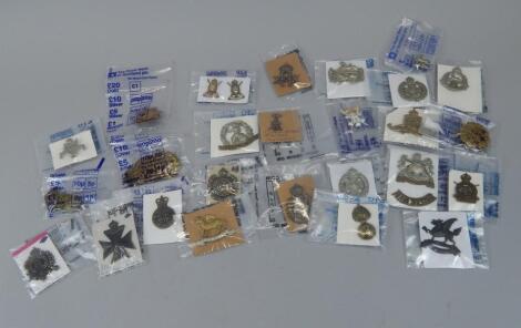 A quantity of military cap badges