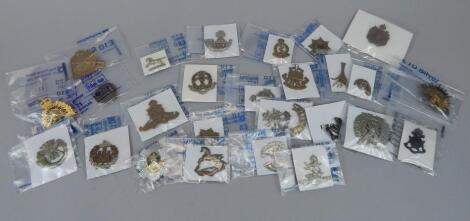 A quantity of military cap badges