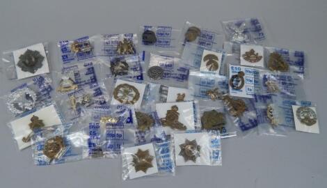 A large quantity of military cap badges