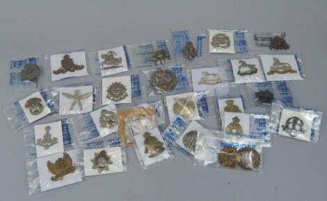 A quantity of military cap badges