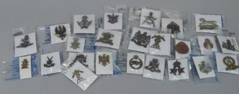 A quantity of military cap badges