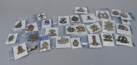 A quantity of military cap badges