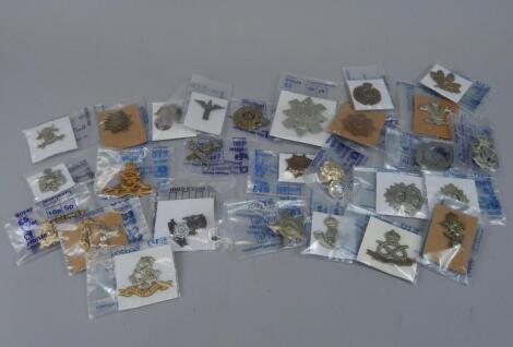 A quantity of military cap badges