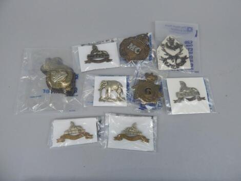 A quantity of military cap badges