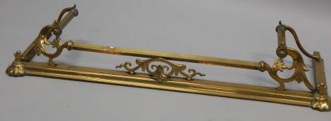 An Art Nouveau style brass fire curb