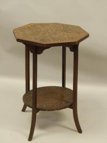 An early 20thC carved oak two tier occasional table