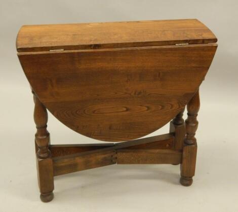 A reproduction oak drop leaf table