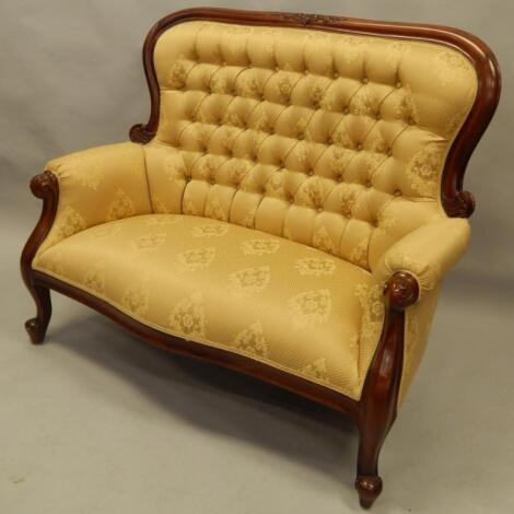 A modern mahogany finished two seater settee and button back gilt coloured material. The upholstery