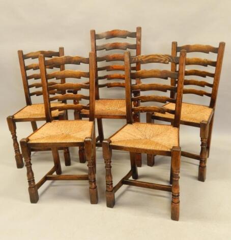 A set of five distressed oak ladder back chairs in the manner of Titchmarsh and Goodwin