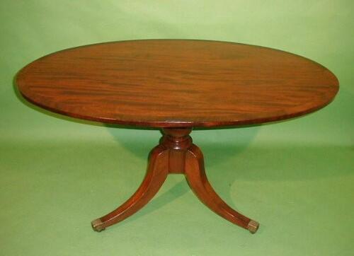 A Regency style mahogany centre table with cross banded oval tilt top on