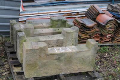 Two pairs of sandstone heads.