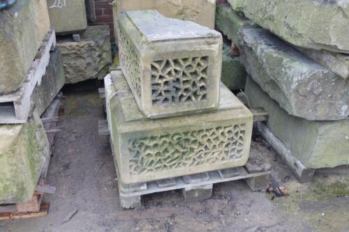 Four ornate sandstone arch blocks.