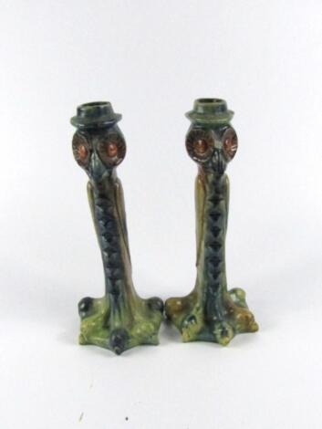 A pair of early 20thC pottery candlesticks