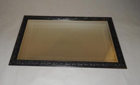 An ebonised rectangular wall mirror