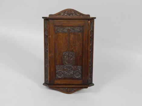 An Art Nouveau oak hanging corner cupboard