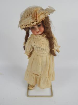A late 19thC bisque headed porcelain doll