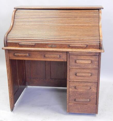 An early 20thC oak roll top desk