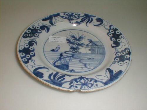 A Delft plate, painted to the well with a naive coastal scene, within a