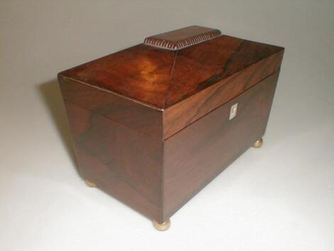 A Victorian rosewood tea caddy of sarcophagus form with gadrooned tablet top