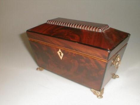 A 19thC figured mahogany tea caddy of sarcophagus form with a dentil tablet top