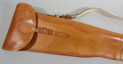 A tan leather shoulder gun case.