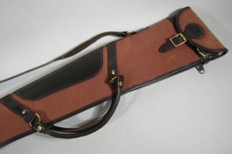 A canvas and leather shoulder gun case.