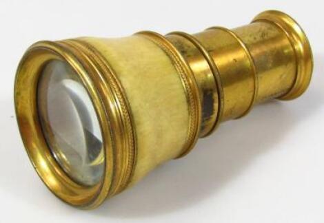 An early 19thC ivory and brass circular table spy glass magnifier