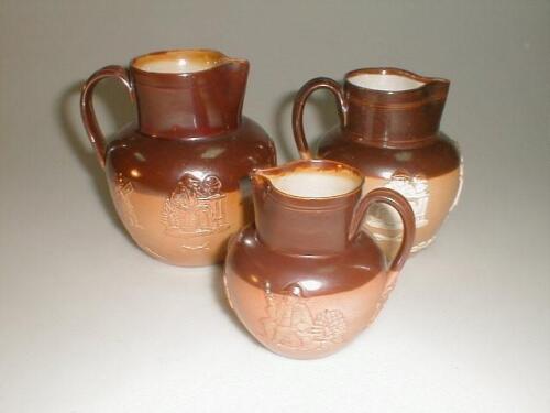 A matched set of three graduated Royal Doulton stoneware jugs