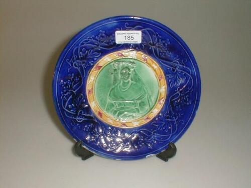 A Majolica plate, centrally bas relief moulded and glazed green with a