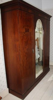 An Edwardian inlaid mahogany triple wardrobe compactum