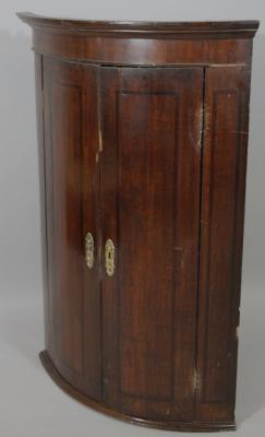 An 18thC oak barrel corner cupboard