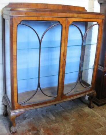 A mid 20thC walnut double door display cabinet