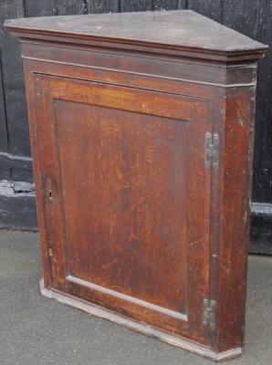 An early 19thC oak hanging corner cupboard