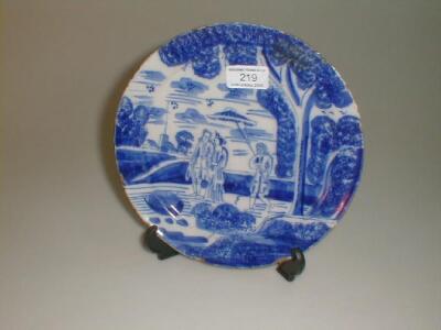 An 18thC Delft plate, painted with a strolling couple and attendant, in