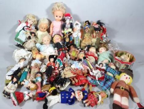 A pressed suitcase containing a large quantity of various mid 20thC and later dolls