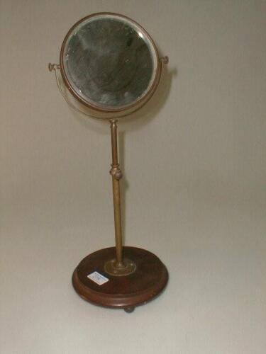 A pedestal mirror with a circular swivel double glass on an adjustable