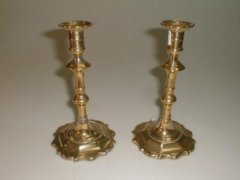 A pair of early 19thC brass candlesticks with fixed sconces over a knopt