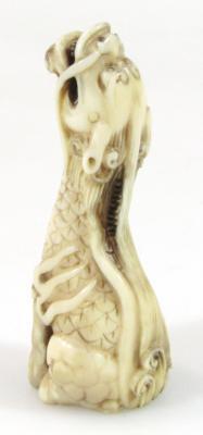 A 19thC ivory figure of a seated dragon