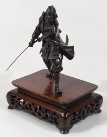 A Japanese Meiji period patinated hollow bronze statue of a standing samurai warrior