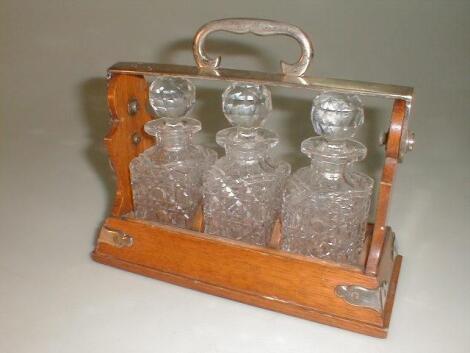 A small Edwardian 1/4 bottle oak tantalus by Benjamens