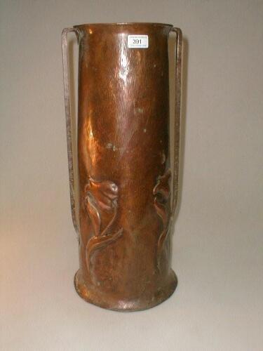 An Art Nouveau embossed copper cylindrical stick stand