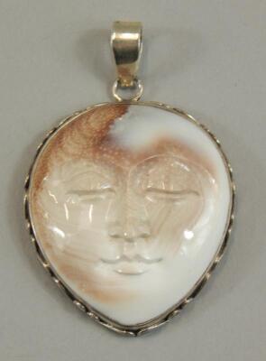 A silver mounted carved shell mask pendant of Shiva