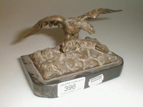 A 19thC bronze figure of an eagle and a snake on a rocky outcrop