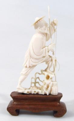 An early 20thC Chinese ivory figure of a fisherman