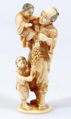 A late 19thC Japanese ivory figure group of a gentleman holding child