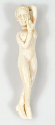 An early 20thC ivory erotic carving formed as a nude female with legs crossed