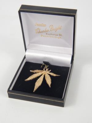 A 9ct gold pendant formed as a cannabis leaf