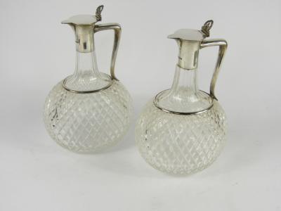 A pair of Edward VII cut glass claret jugs with silver mounts