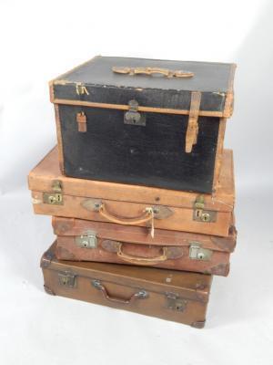 Four leather and canvas bound suitcases.