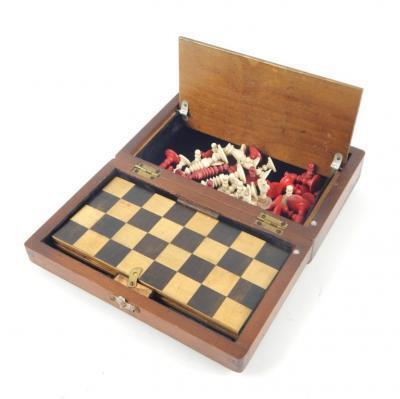 A 19thC white and red stained bone travelling chess set and board